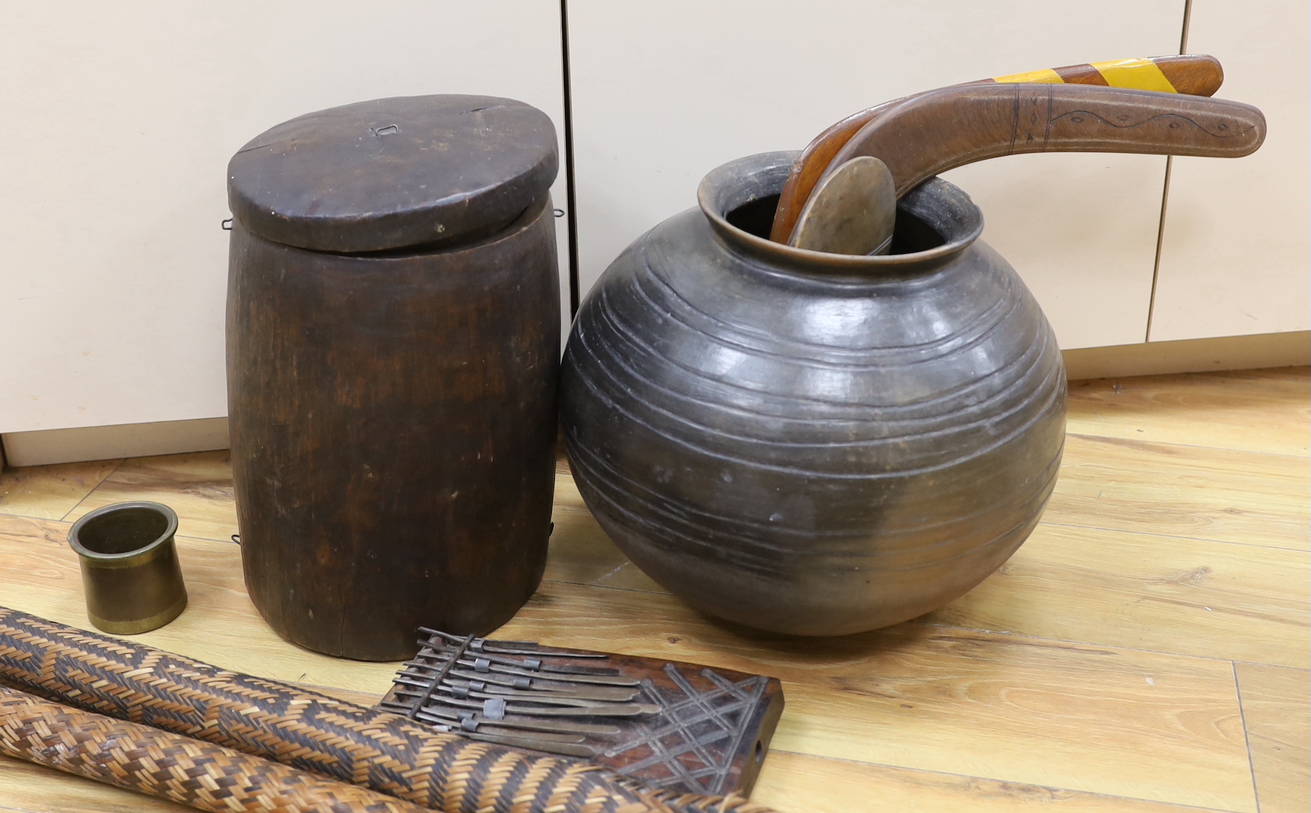 An earthenware bowl, two woven arrow quivers, a bronze pot, a wooden pot and lid, a fertility figure, two boomerangs, etc. (9)